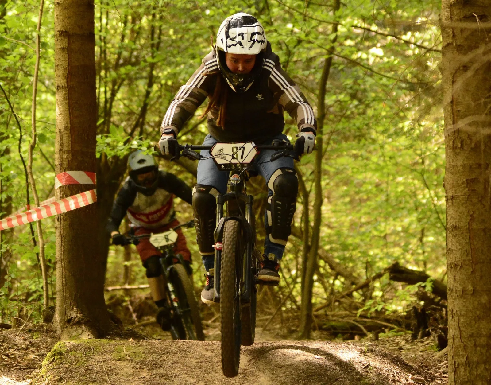 Riderka na rowerze górskim pokonuje leśną przeszkodę